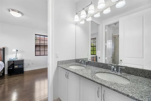 a bathroom with a granite countertop sink and a mirror