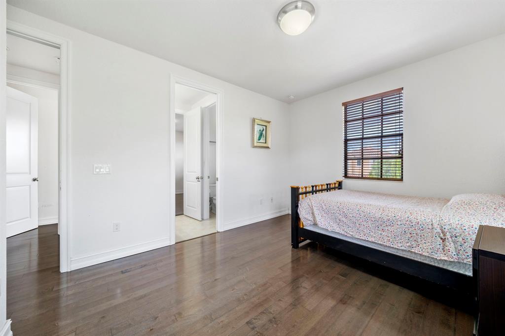 7302 Northwest 111th Way Parkland, FL 33076 - Photo 30 of 36 a bedroom with a bed and wooden floor