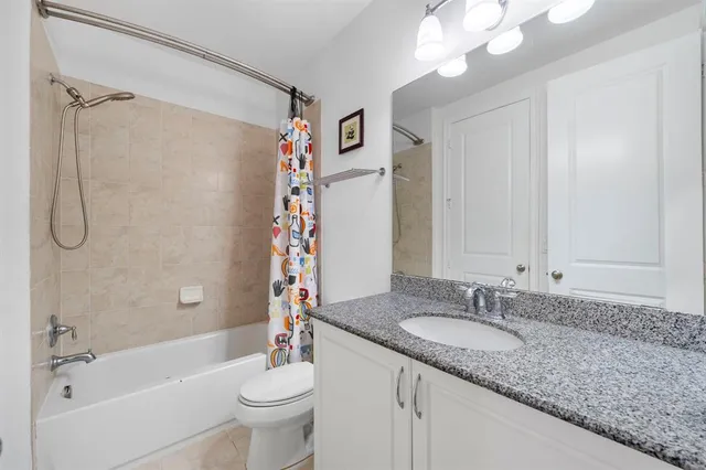 a bathroom with a granite countertop sink a toilet and shower