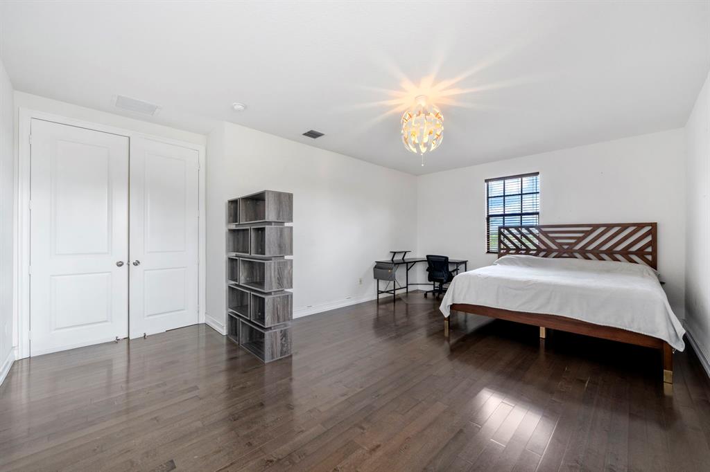 7302 Northwest 111th Way Parkland, FL 33076 - Photo 33 of 36 a bedroom with a bed and a chandelier