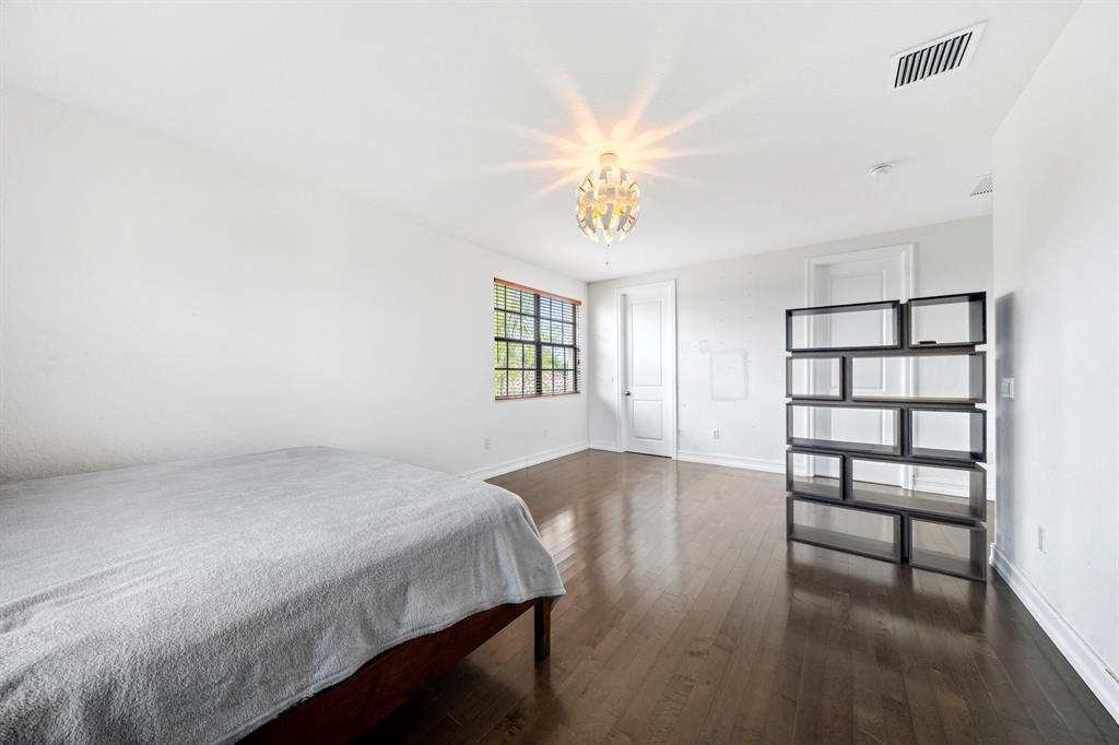 7302 Northwest 111th Way Parkland, FL 33076 - Photo 34 of 36 a bedroom with a bed table and chair