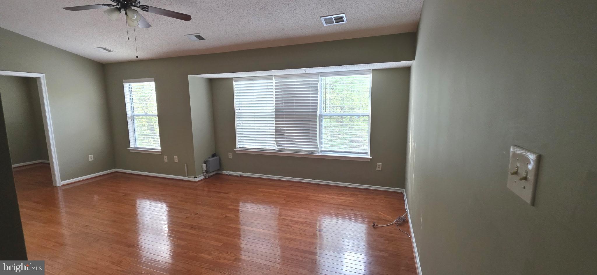 14201 Woolen Oak Court, Unit 932 Silver Spring, MD 20906 - Photo 3 of 10 a view of an empty room with a window and wooden floor