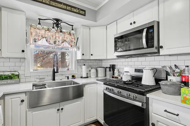 a kitchen with stainless steel appliances granite countertop a sink stove and cabinets