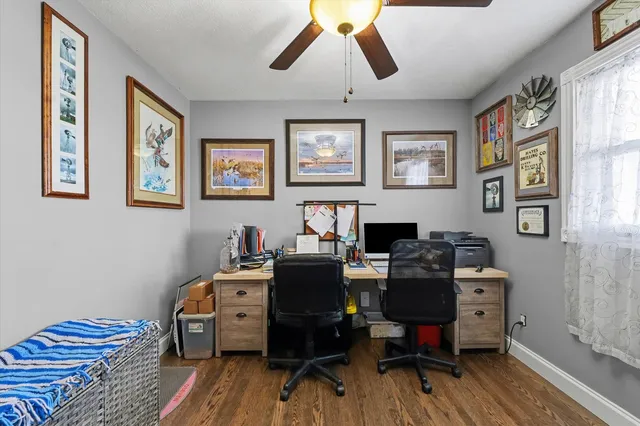 a view of a workspace with furniture and wooden floor