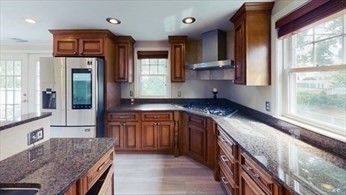 a kitchen with stainless steel appliances granite countertop a sink and a stove