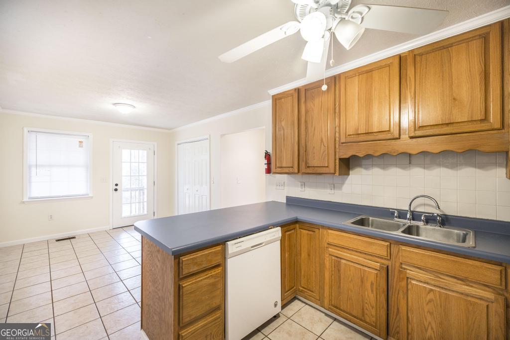 411 Cypress Drive Dublin, GA 31021 - Photo 15 of 31 a kitchen with granite countertop a sink window and cabinets