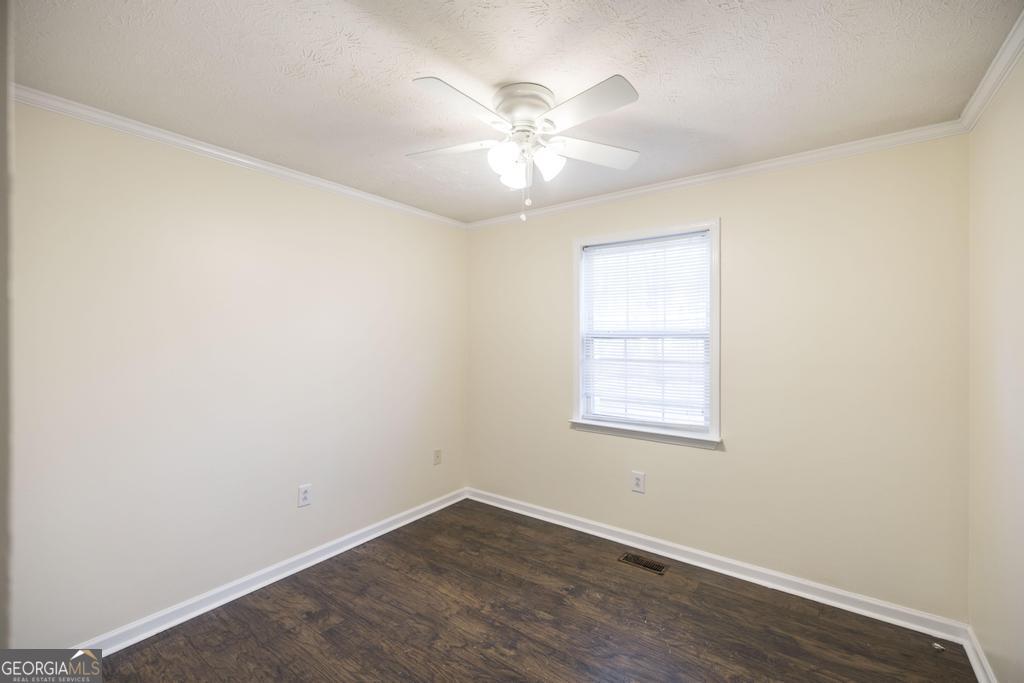 411 Cypress Drive Dublin, GA 31021 - Photo 22 of 31 an empty room with wooden floor and windows