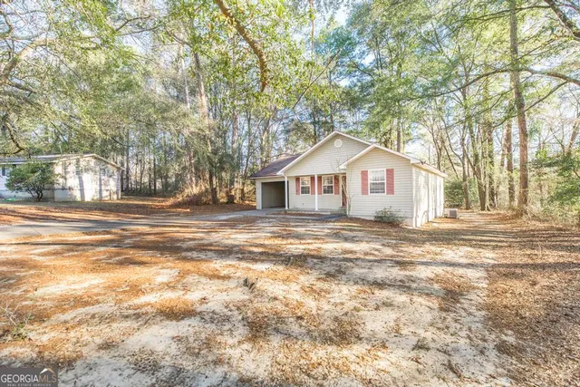a view of a house with a yard and large tree