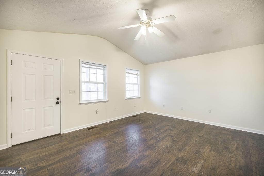 411 Cypress Drive Dublin, GA 31021 - Photo 9 of 31 an empty room with wooden floor fan and windows