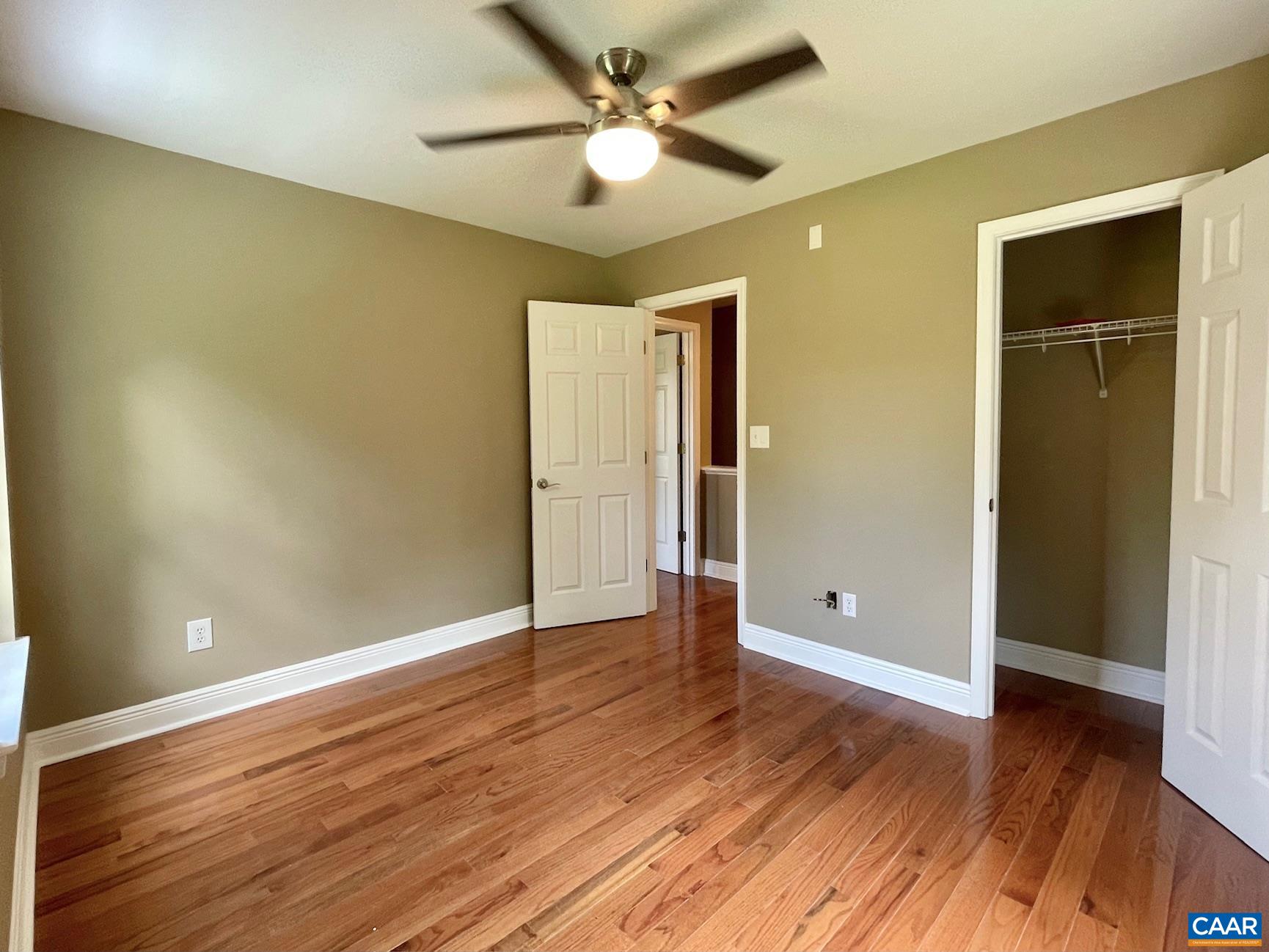 5420 Cove Garden Road Covesville, VA 22931 - Photo 16 of 27 an empty room with wooden floor and a ceiling fan