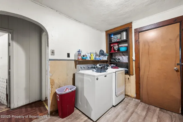 a storage room with water heater and wooden cabinets