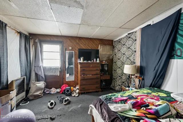 a bedroom with furniture and a flat screen tv