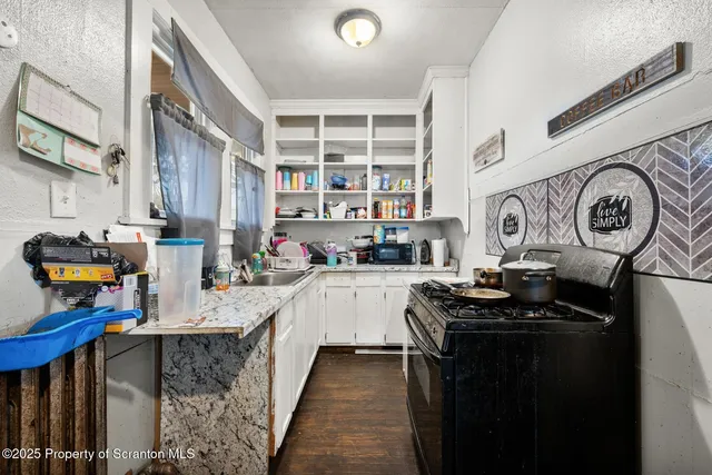 a kitchen with stainless steel appliances granite countertop a stove and cabinets