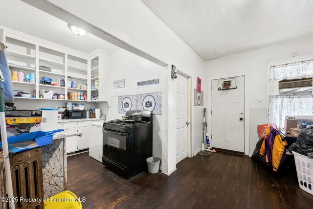 a kitchen with stainless steel appliances and wooden floor