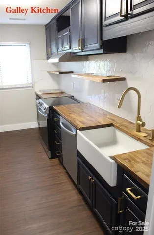 a kitchen with stainless steel appliances granite countertop a sink and a stove
