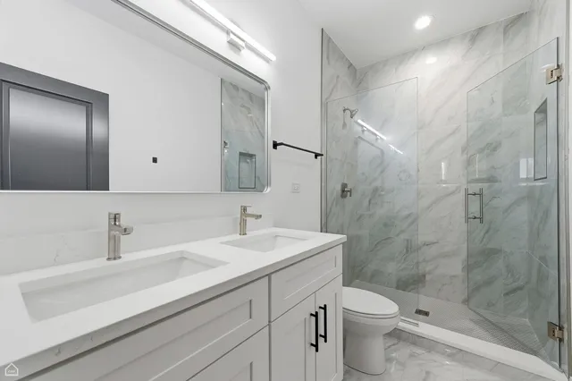 a bathroom with a sink a toilet and shower