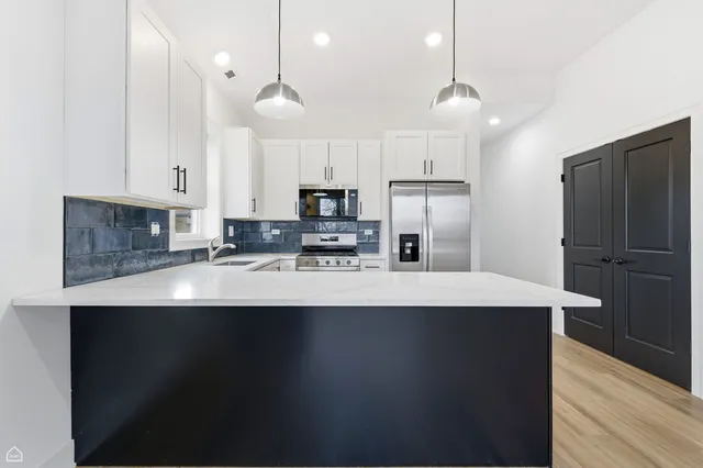 a kitchen with kitchen island a sink stainless steel appliances and cabinets