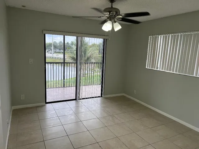 a view of a livingroom with a chandelier fan and windows