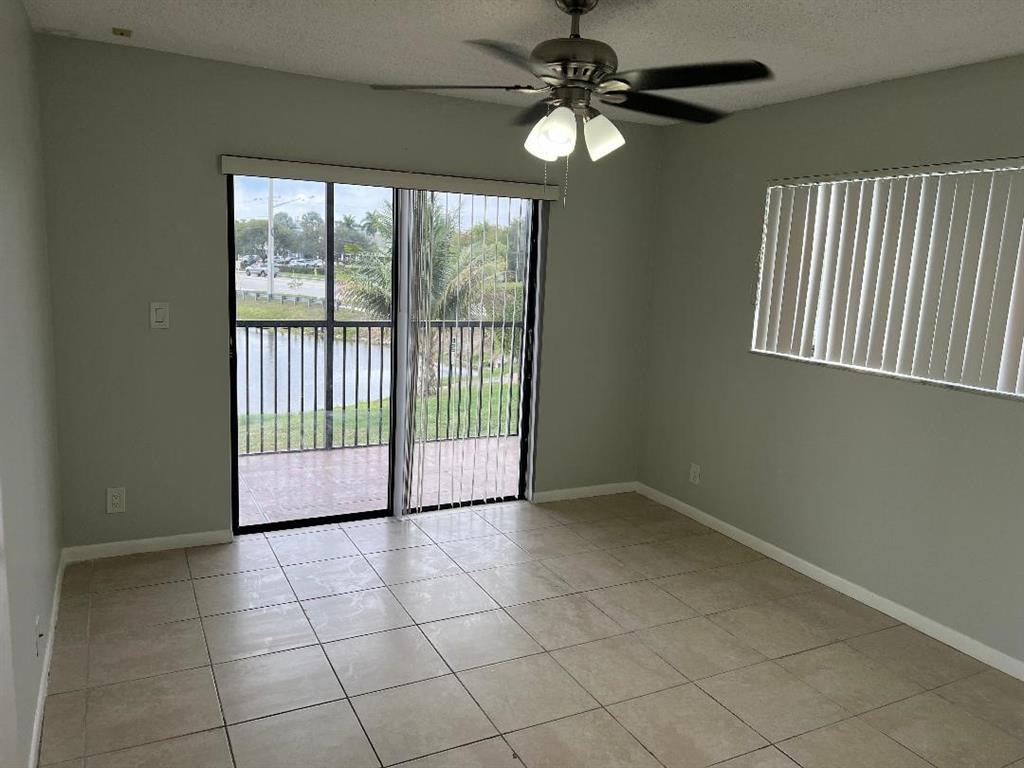 9920 Northwest 68th Place, Unit 210 Tamarac, FL 33321 - Photo 12 of 26 a view of a livingroom with a ceiling fan and window