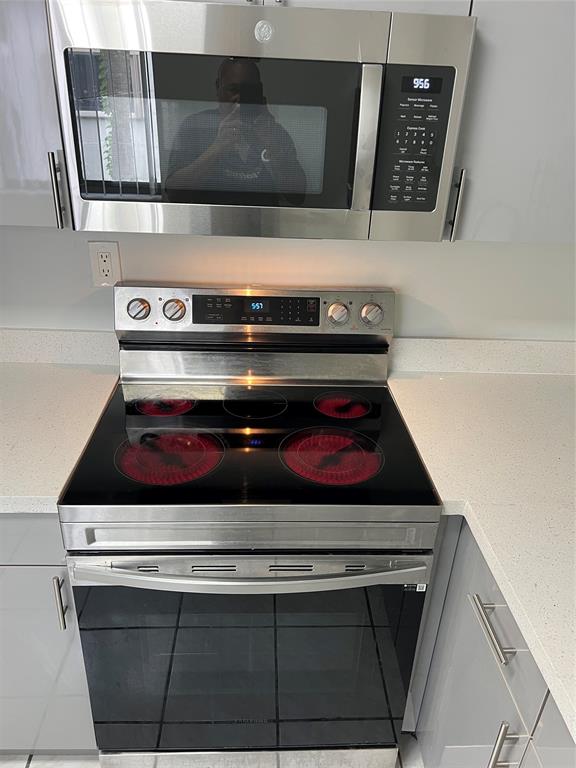 9920 Northwest 68th Place, Unit 210 Tamarac, FL 33321 - Photo 7 of 26 a stove top oven sitting inside of a kitchen