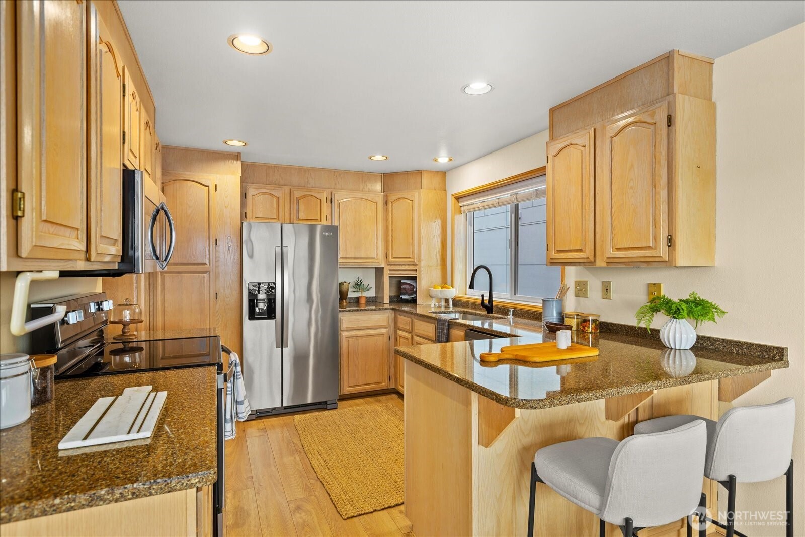 233 3rd Avenue South, Unit 305 Edmonds, WA 98020 - Photo 13 of 34 a kitchen with stainless steel appliances granite countertop sink refrigerator and cabinets