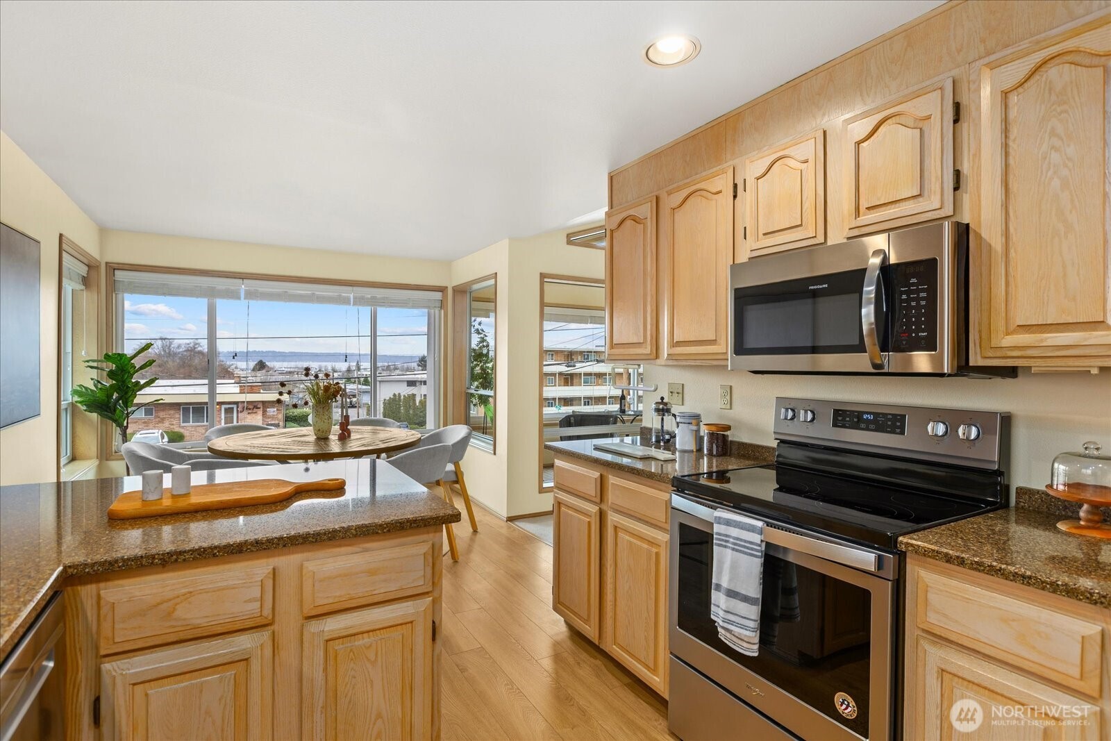 233 3rd Avenue South, Unit 305 Edmonds, WA 98020 - Photo 15 of 34 a kitchen with stainless steel appliances granite countertop a stove a sink and a microwave