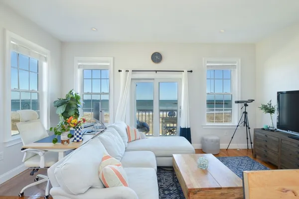 a living room with furniture a flat screen tv and a large window