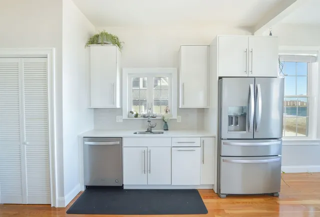a kitchen with a refrigerator sink and cabinets