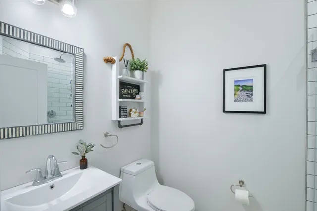 a bathroom with a toilet a sink and mirror