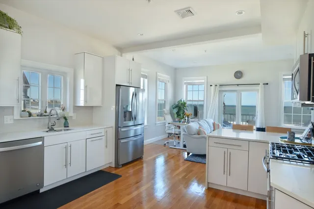 a kitchen with white cabinets and stainless steel appliances