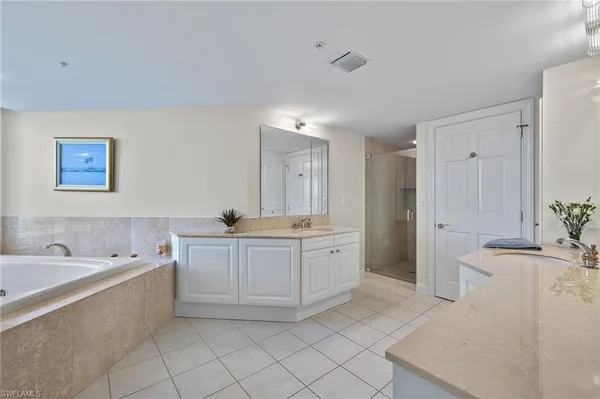 a large bathroom with a double vanity sink a mirror and a bathtub