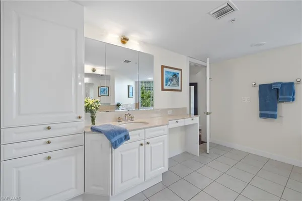 a kitchen with white cabinets and sink