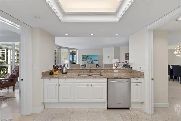 a kitchen with white cabinets appliances and a sink