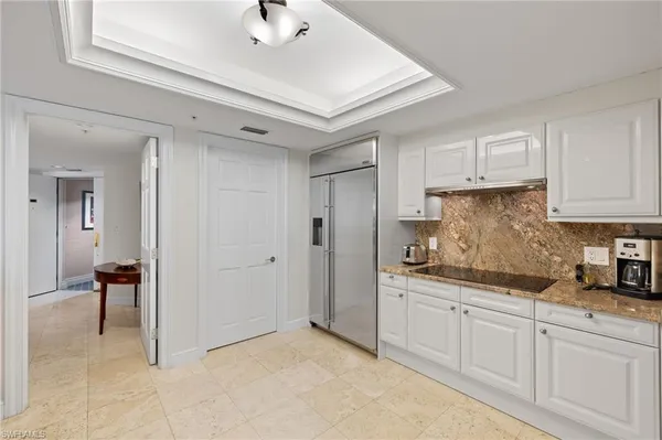 a kitchen with white cabinets and sink