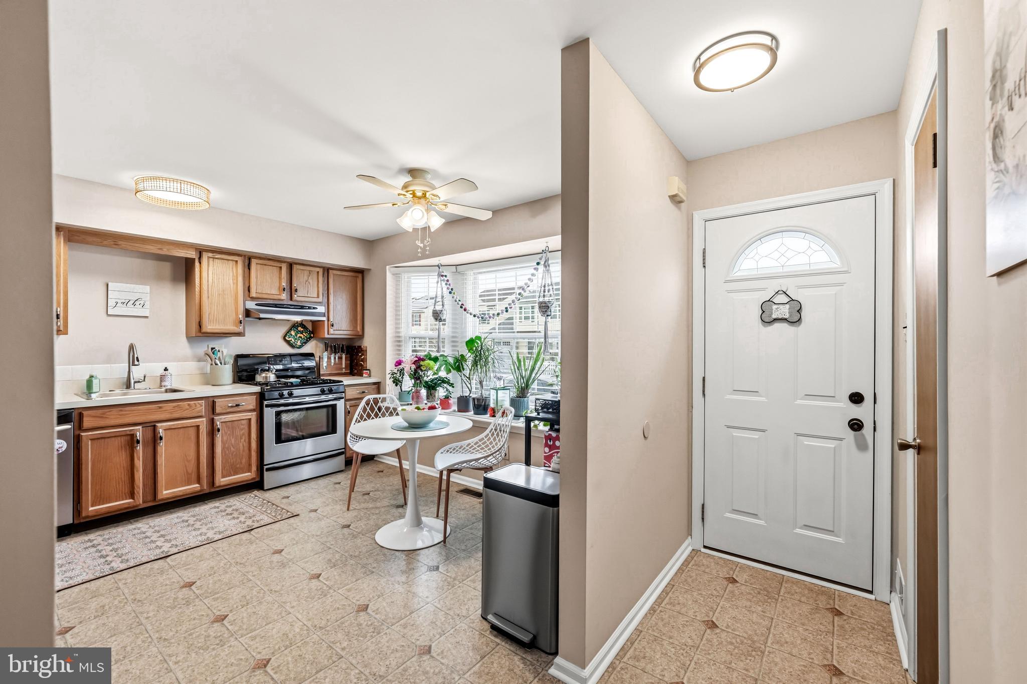 26 Blue Jay Drive Clementon, NJ 08021 - Photo 11 of 48 a kitchen with a refrigerator a sink dishwasher a stove and a dining table with wooden floor