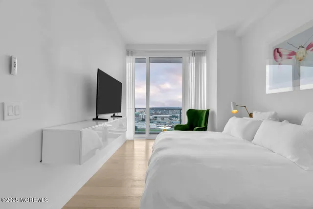 a spacious bedroom with a large bed and a flat screen tv