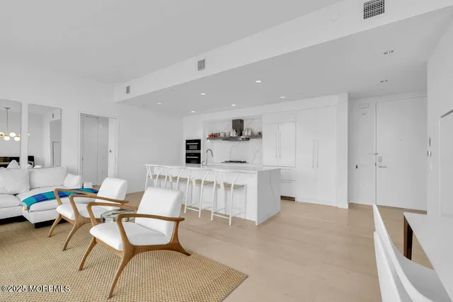 a living room with furniture a dining table and kitchen view