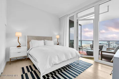 a bedroom with a bed couch and large window