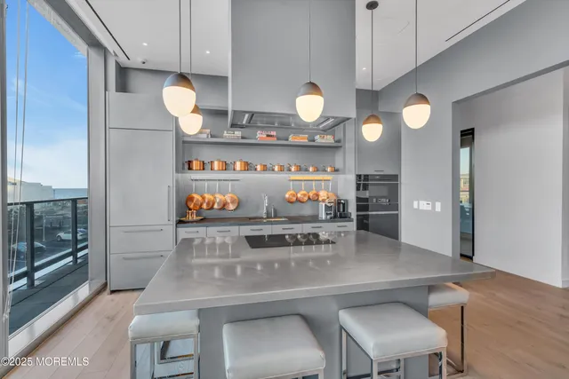 a kitchen with stainless steel appliances kitchen island a table and chairs in it