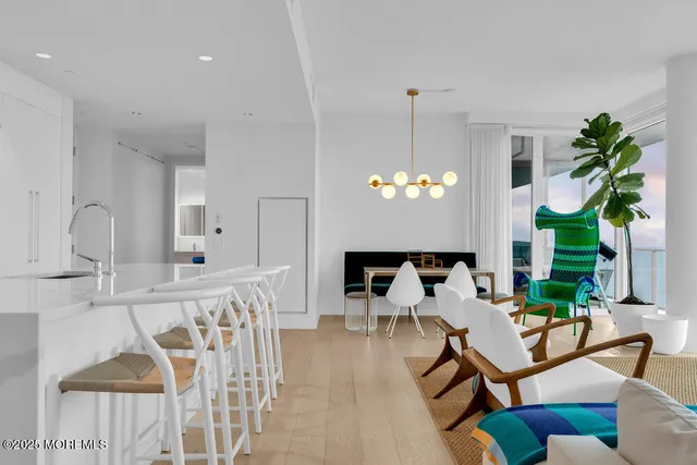 a living room with furniture a chandelier and a dining table