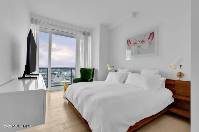 a bedroom with a large bed and a chandelier