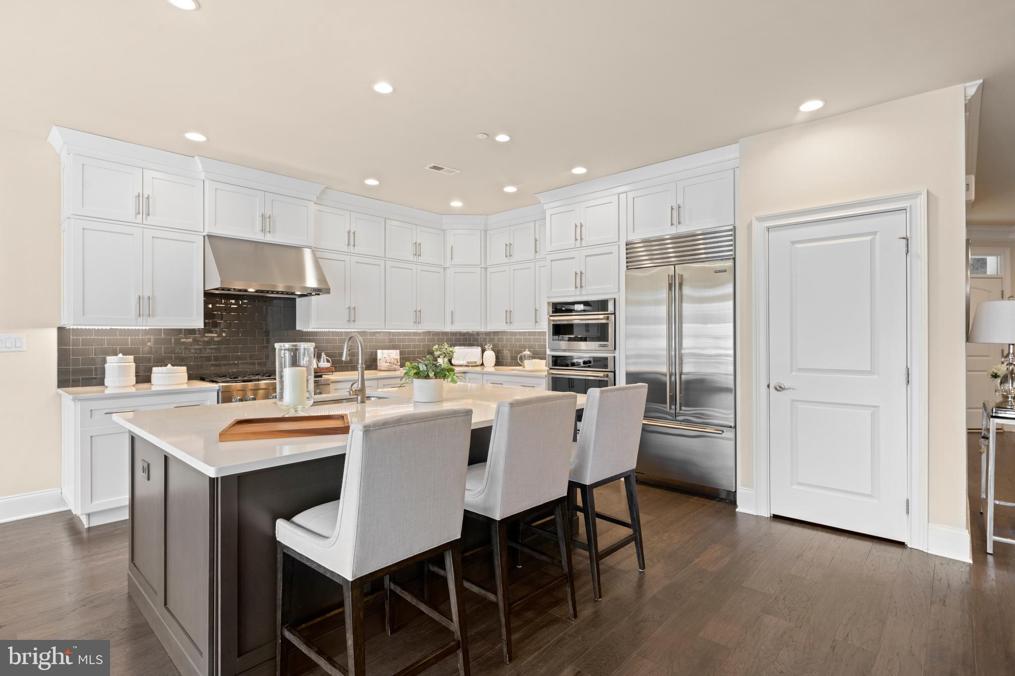 3860 Meadow View Farm Road Newtown Square, PA 19073 - Photo 13 of 40 a kitchen with stainless steel appliances kitchen island granite countertop a dining table chairs and white cabinets