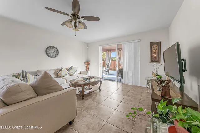 a living room with furniture a chandelier fan and a rug