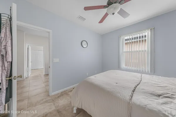 a bedroom with a bed and a chandelier fan