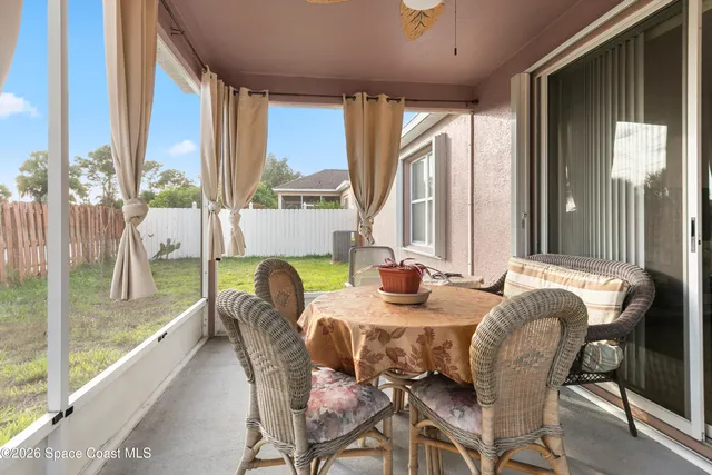 a dining room with furniture and a floor to ceiling window