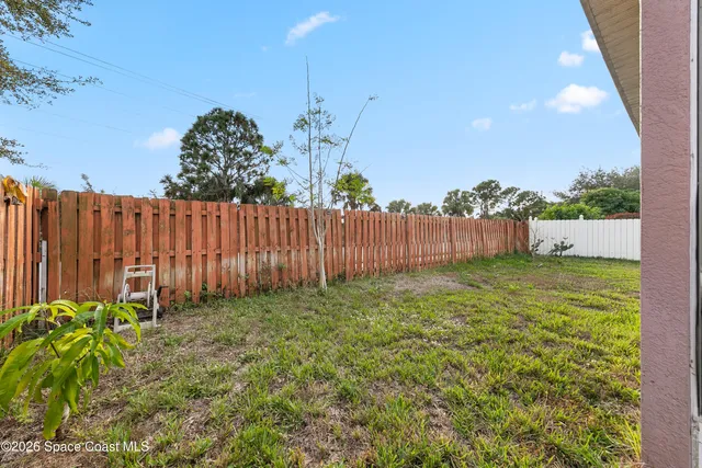 a view of a backyard with a garden and deck