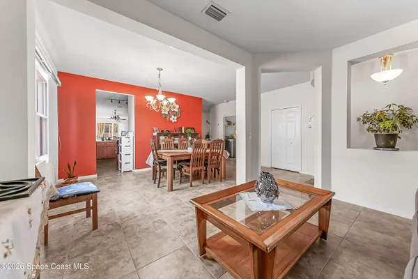 a living room with furniture a dining table and a potted plant