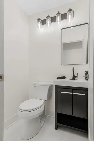 a bathroom with a toilet a sink and mirror