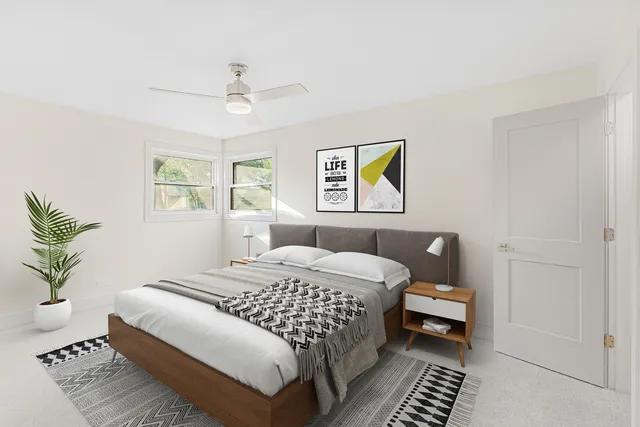 a bedroom with a bed a painting and a window