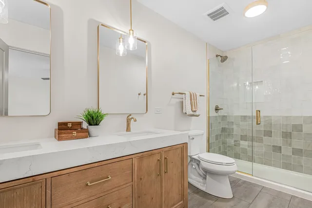 a bathroom with a sink a toilet and shower